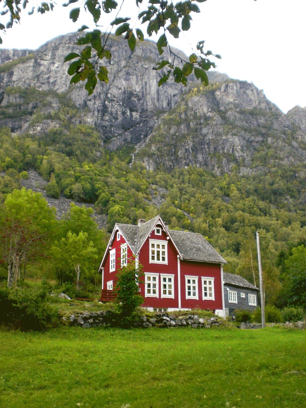 Rødt hus i bunnen av et fjell